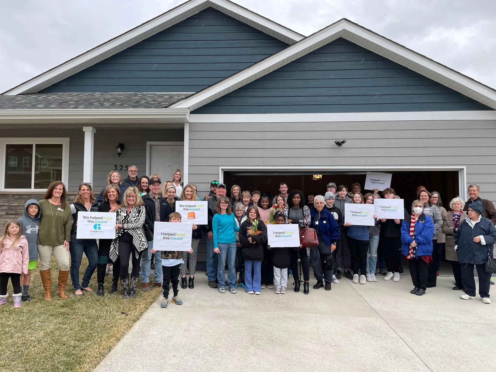 Group of people in front of a home.
