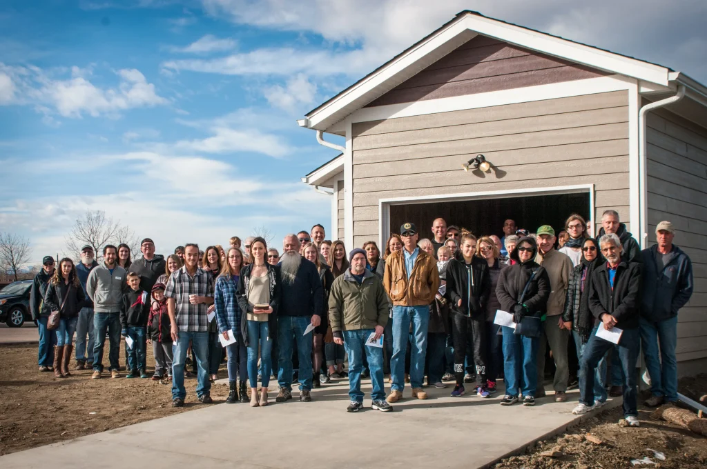 Group of people in front of a home.