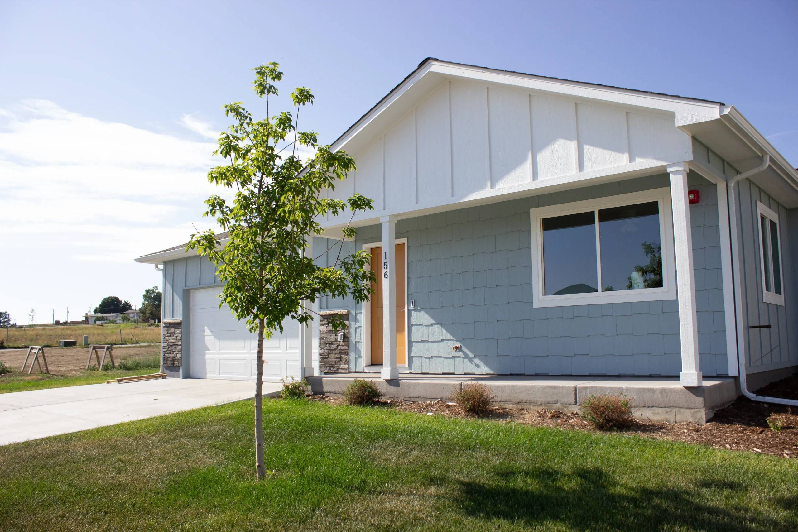 Blue house with tree in front yard.