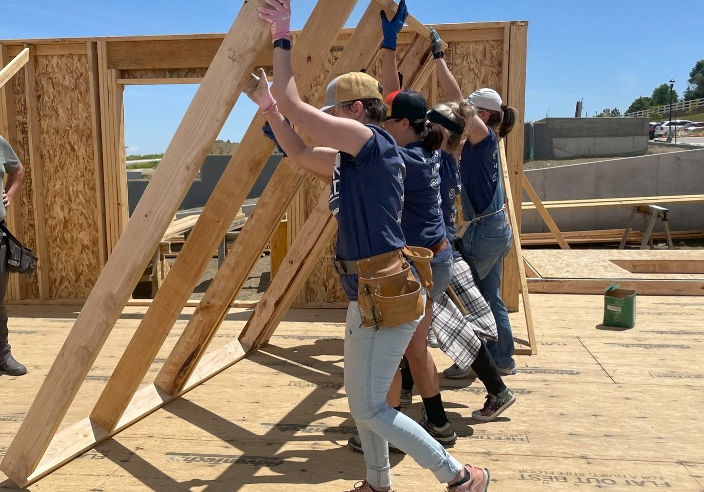 Vols-Construction (1) Group of volunteers lifting a wall frame.